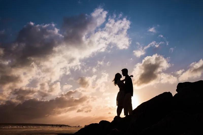 Couple silhouetted against a sunset sky